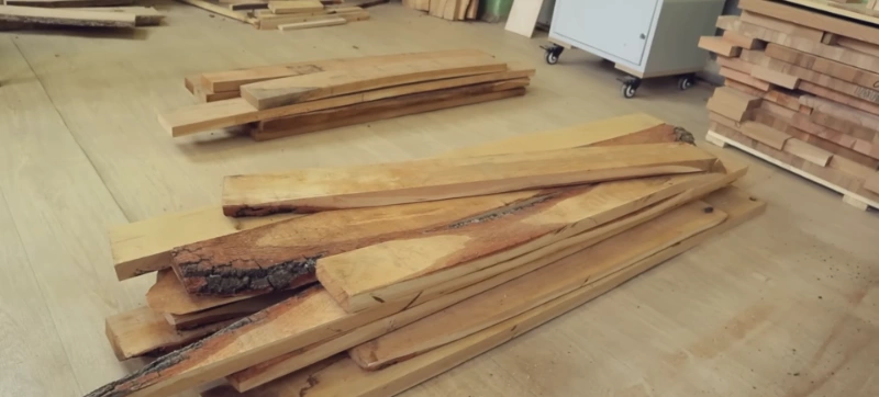 Large stack of cleaned reclaimed wood beams and planks sorted by size in sustainable salvage warehouse